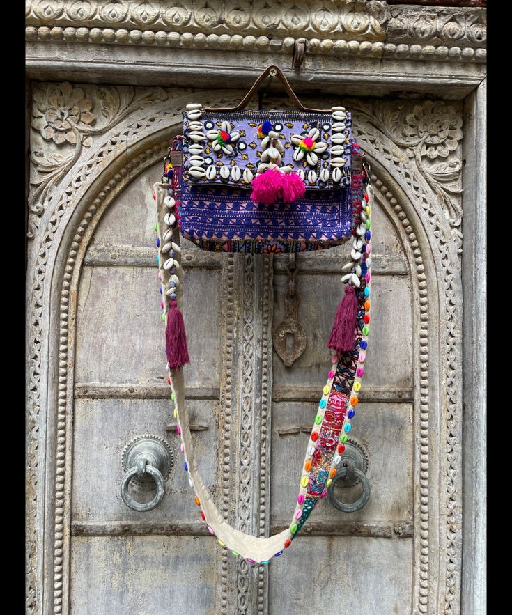 About bag  Indo-gypsy fusion, everyday use hand bag made from Banjara fabrics sourced from Vintage tribal costumes of regions of Rajastan and Gujarat. These are embellished with light catching coins, and intricate bead work tassels. Size - length 15 inches/ width 21 inches Company details:  Company name: Houseoftextile  Contact number: +919784447473  Email id: houseoftextile77@gmail.com  Shipping & custom : Delivery through one of the finest service providers : Skyway, Fedex, UPS  And DHL. Any l Multicolor Handwork Bags For Festive Occasions, Festive Shoulder Bag With Handwork, Artisan Multicolor Embroidered Shoulder Bag For Festivals, Handmade Bohemian Purple Crochet Bag, Handmade Multicolor Embroidered Shoulder Bag For Festivals, Handmade Bags For Festival, Handmade Shoulder Bag With Multicolor Embroidery For Festivals, Traditional Embroidered Purple Bag, Festive Bag With Mirror Work For Festivals