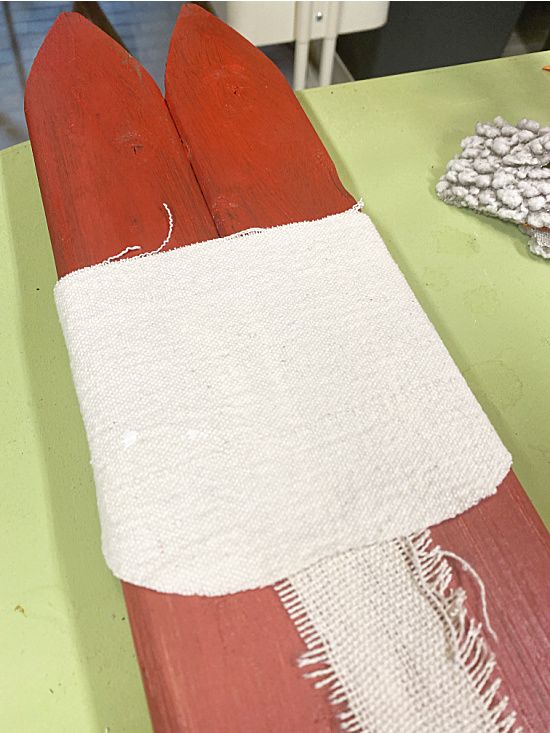 an old pair of skis sitting on top of a green table next to a white and red scarf