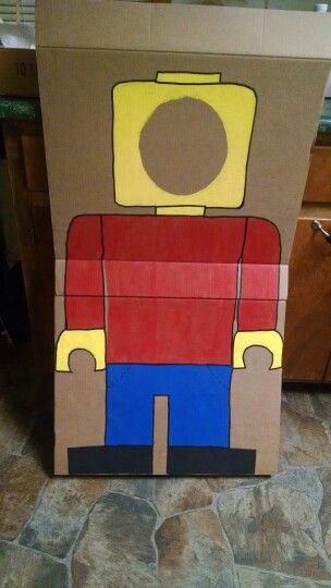 a cardboard box with a lego character painted on the front and sides, sitting on a kitchen floor