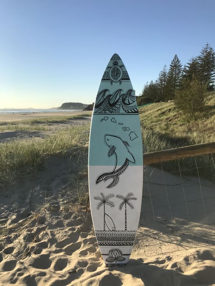 a surfboard sitting on top of a sandy beach