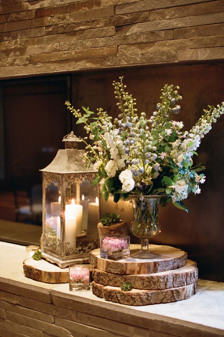 a vase with flowers and candles on top of a table