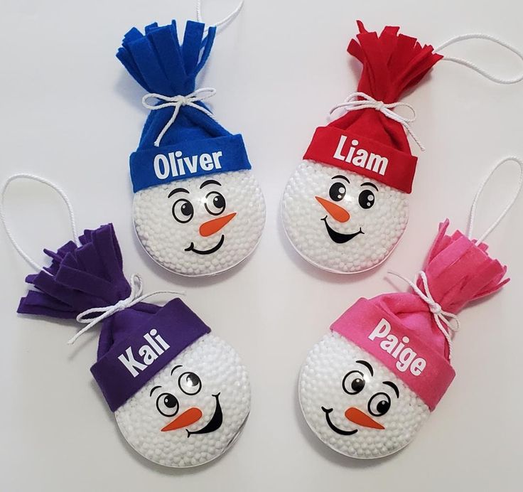 three golf balls with different colored hats on them and the names of their respective players