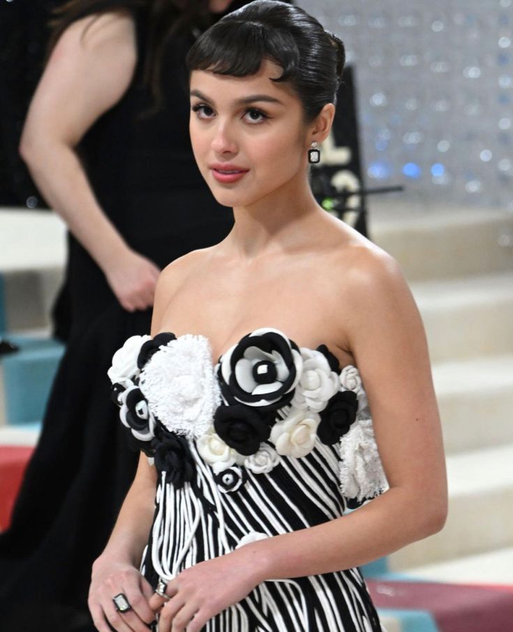 a woman in a black and white dress posing for the camera