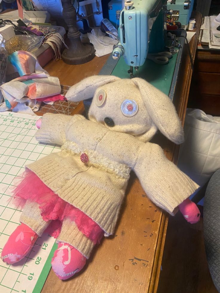 a stuffed animal sitting on top of a table next to a sewing machine and other items