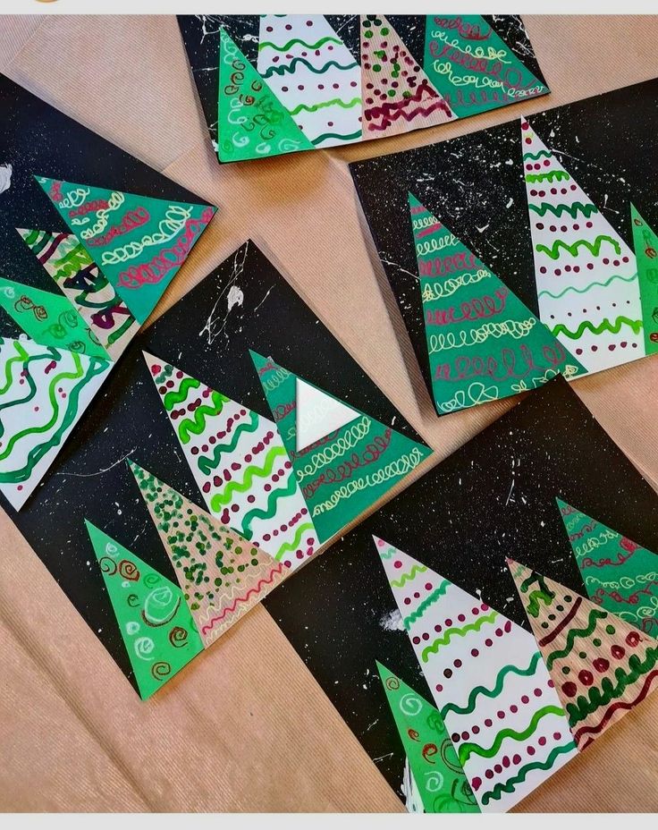 paper christmas trees are laid out on top of black and white papers with green trimmings