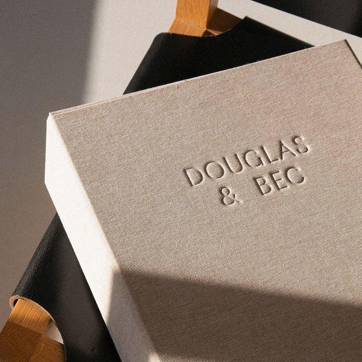 two boxes that are sitting next to each other on a wooden stand with the words douglas & bec printed on them