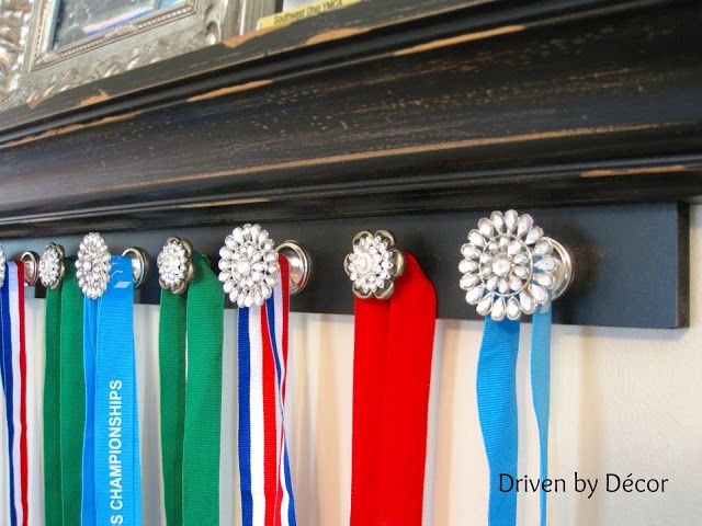 several medals hang on a wall with ribbons