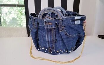 a purse made out of jeans and studded with gold chains is sitting on a table