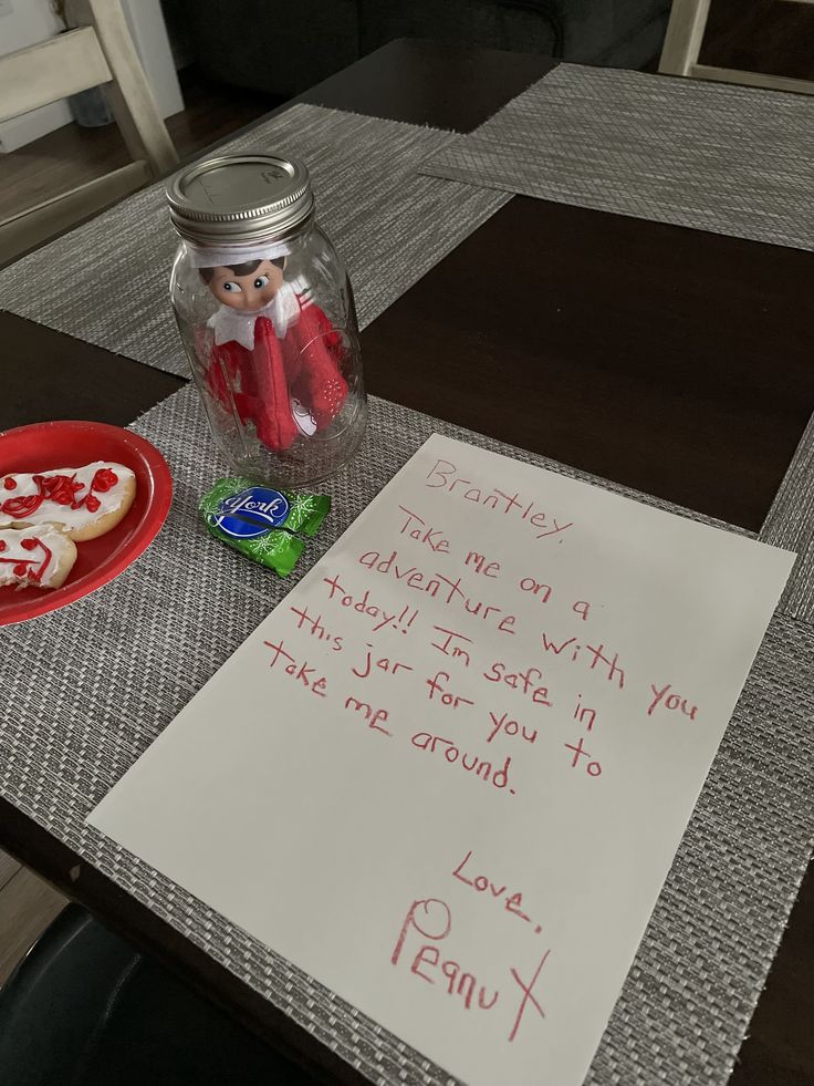 a table with a note, cookies and candy in a jar on top of it