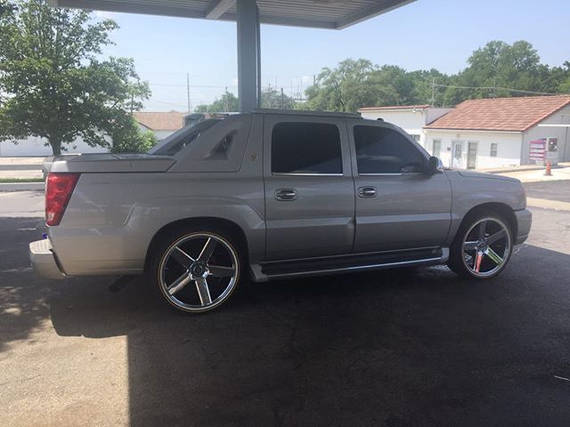 a silver truck parked in a parking lot next to a gas station with no one around