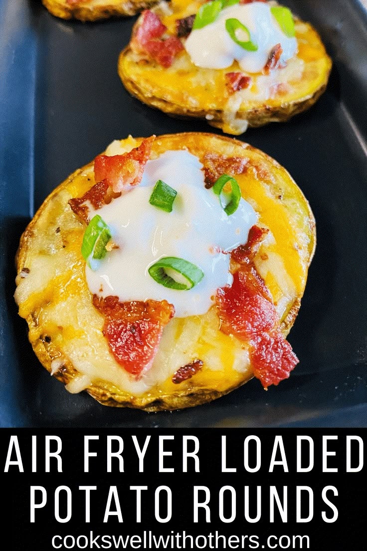 air fryer loaded potato rounds with bacon and cheese on top in a baking pan