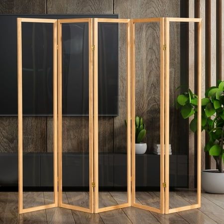 a room divider made out of wood in front of a plant on the floor