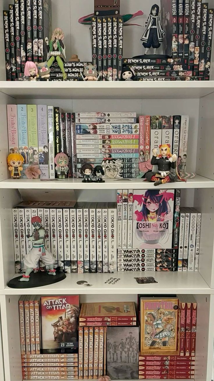 a white book shelf filled with lots of books and anime figurines on top of it