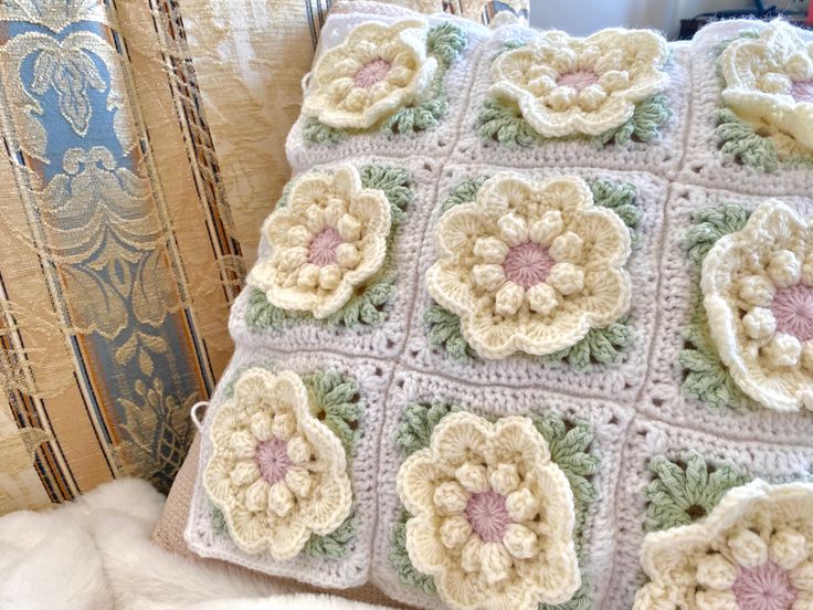 a crocheted pillow with flowers on it