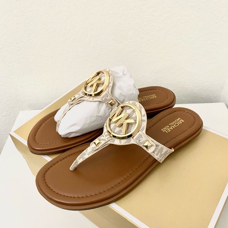 100% Michael Kors Authentic Guarantee And Firm Price! Details New With Box Vanilla Color Gold Tone Hardware Sandal Logo-Print Canvas 89.4% Coated Canvas/9.6% Polyester/1% Polyurethane Lining: Polyurethane Blend Sole: Rubber Open Toe Slip On Imported Flip Flops Michael Kors, Designer Toe Post Sandals For Beach, Designer Flat Flip Flops For Beach, Michael Kors Gold Sandals For Beach, Michael Kors Gold Sandals For Summer, Michael Kors Slip-on Sandals For Vacation, Michael Kors Gold Sandals With Round Toe, Michael Kors Beach Sandals With Cushioned Footbed, Designer Flip Flops For Spring Beach Season