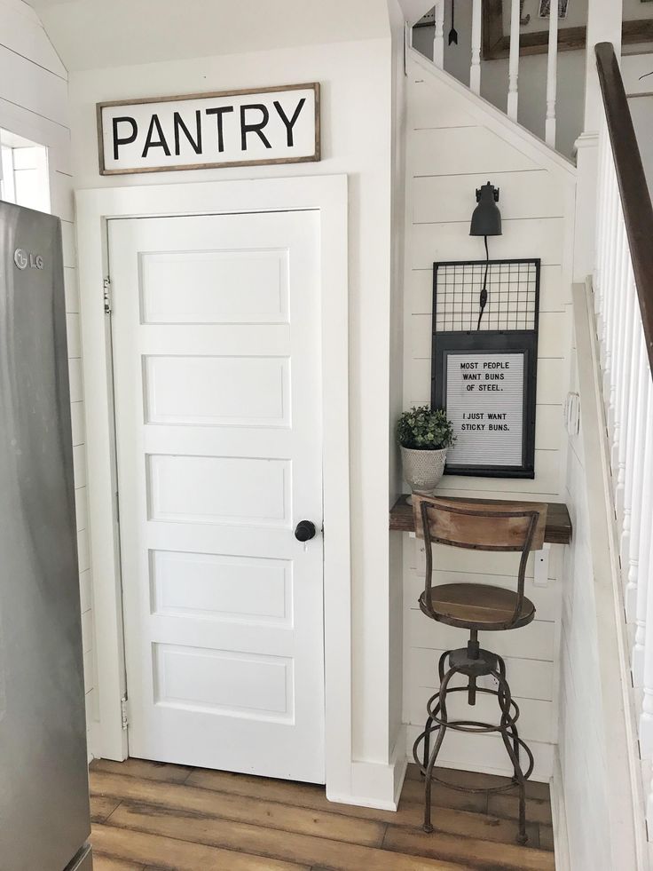 a white door with the word pantry above it and a chair in front of it