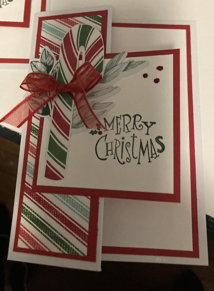 two christmas cards with red and green ribbons on them, one has a merry christmas message