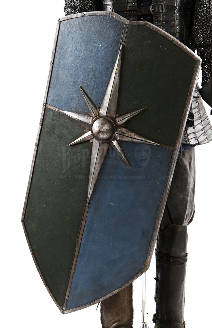 a man dressed in armor and holding a shield with a pointed star on it's side