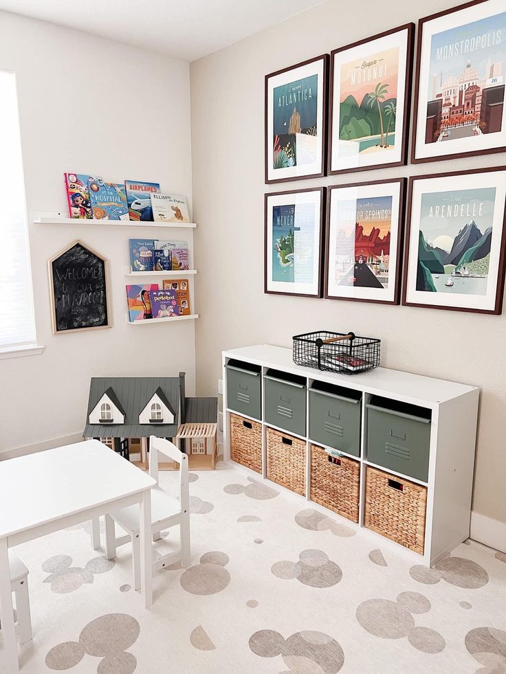 a child's playroom with white furniture and pictures on the wall above it