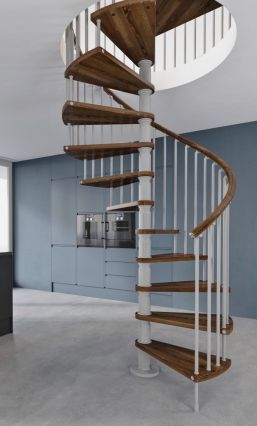 a spiral staircase in an empty room with blue walls