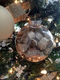 an ornament hanging from a christmas tree filled with old book pages and lights