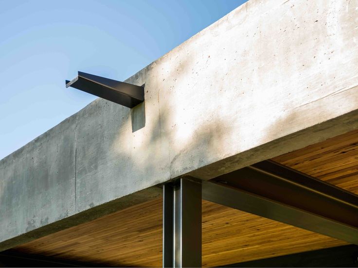 the corner of a concrete building with wood siding