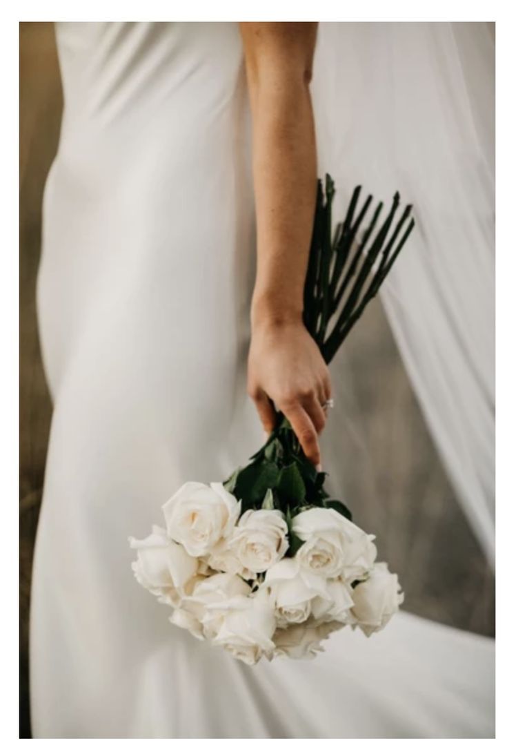 a person holding a bouquet of white flowers