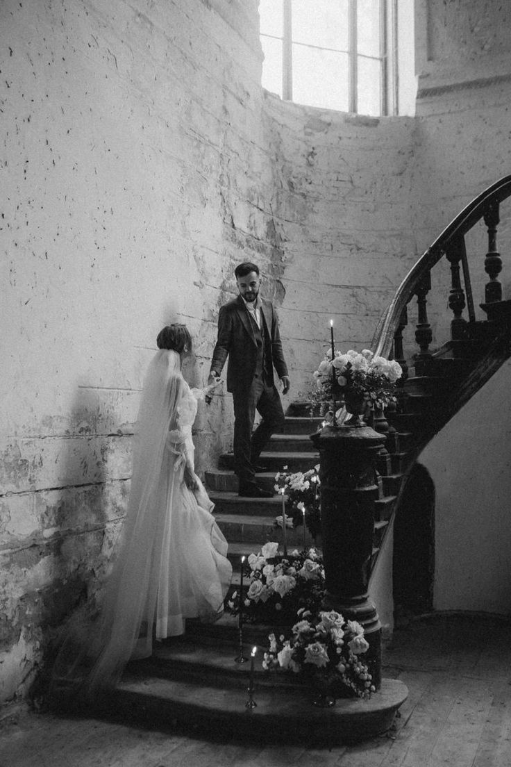 a bride and groom walking down the stairs at their wedding ceremony in an old building