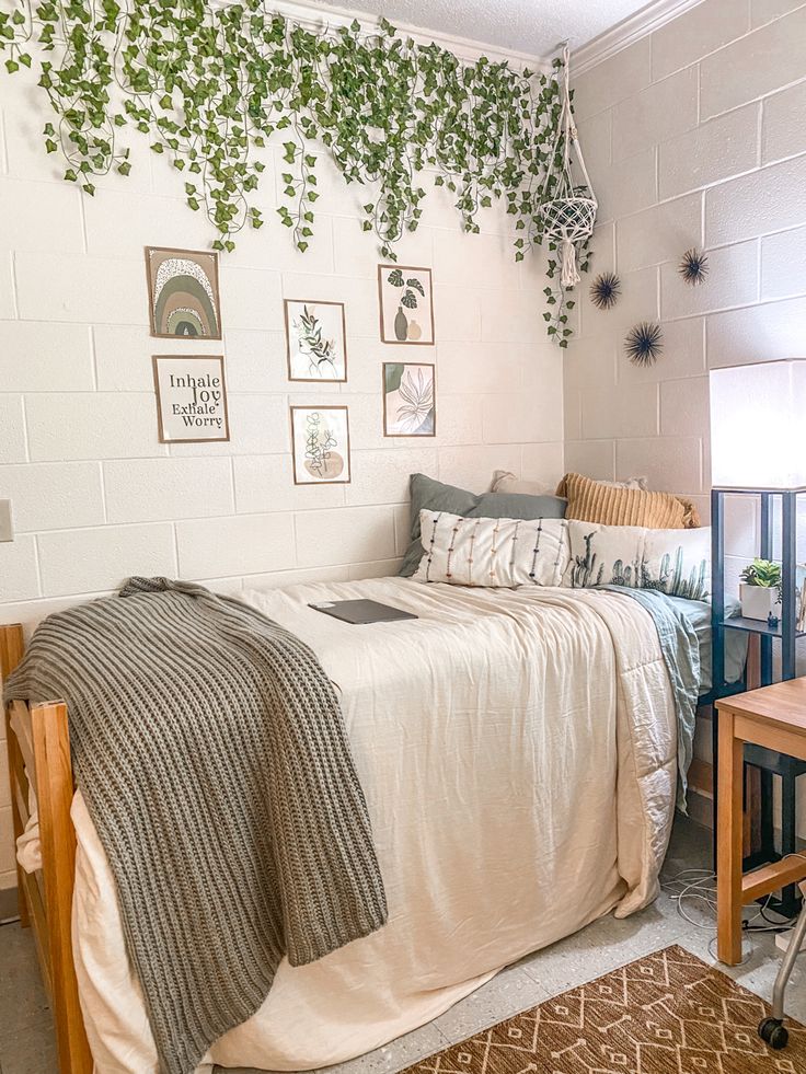 a bedroom with white walls and green plants on the wall above the bedspread