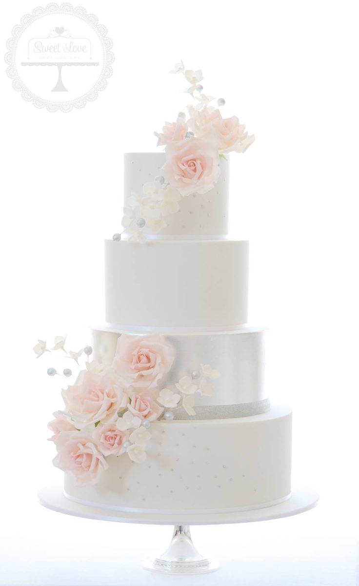 a white wedding cake with pink flowers on top