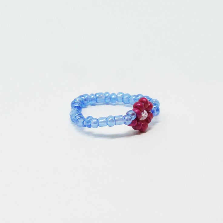 Color: Purple, Fusia Material: Bead Dimensions: 0.75" Diameter Stretchy, one size fits all. Blue Beaded Rings As Gifts, Blue Beaded Rings For Gifts, Blue Beaded Rings As Gift, Red Beaded Rings For Gifts, Blue Beaded Rings As A Gift, Red Beaded Rings As Gift, Red Beaded Rings Perfect As Gifts, Adjustable Round Jewelry With Bead Caps, Blue Rings With Colorful Beads For Gift