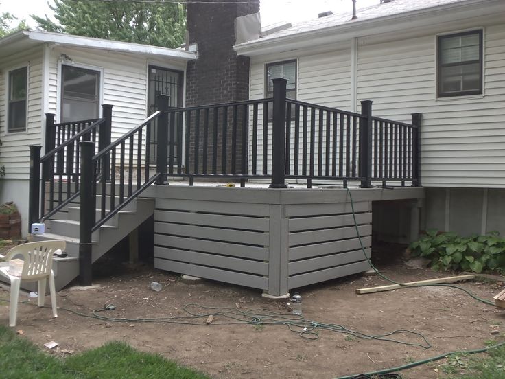 a house with a deck and stairs in the front yard