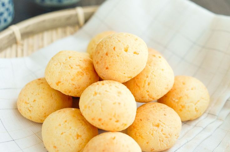 a pile of small round pastries sitting on top of a white cloth covered table