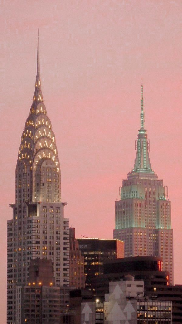 the city skyline is lit up at night, with skyscrapers in the foreground