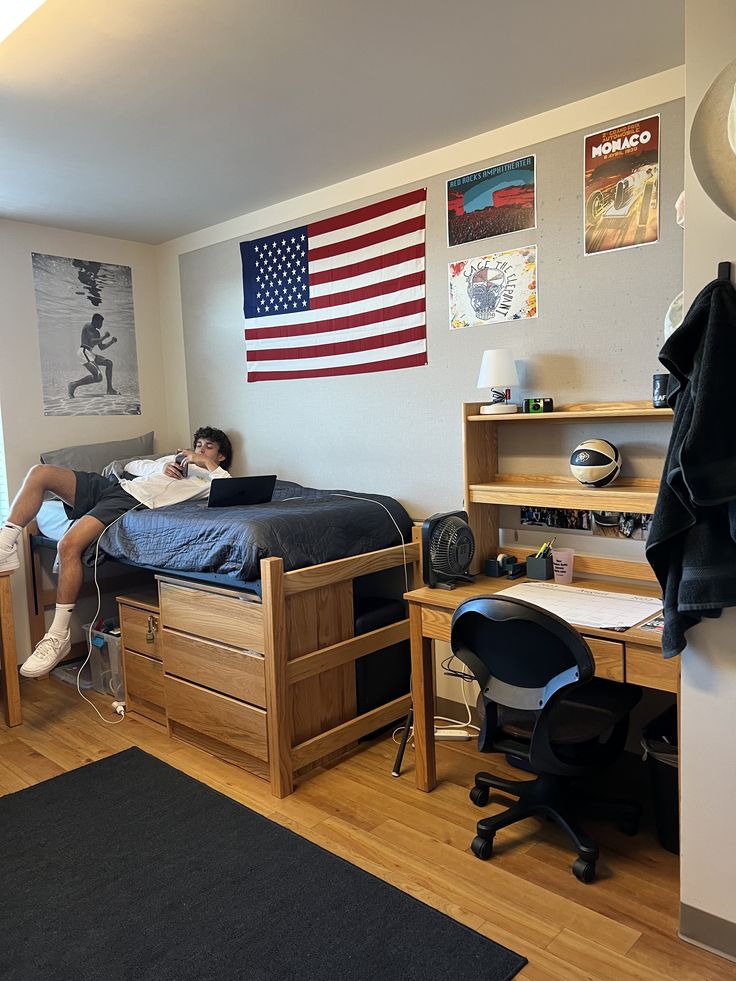 a person sitting on a bed in a room with wooden floors and walls, reading a book