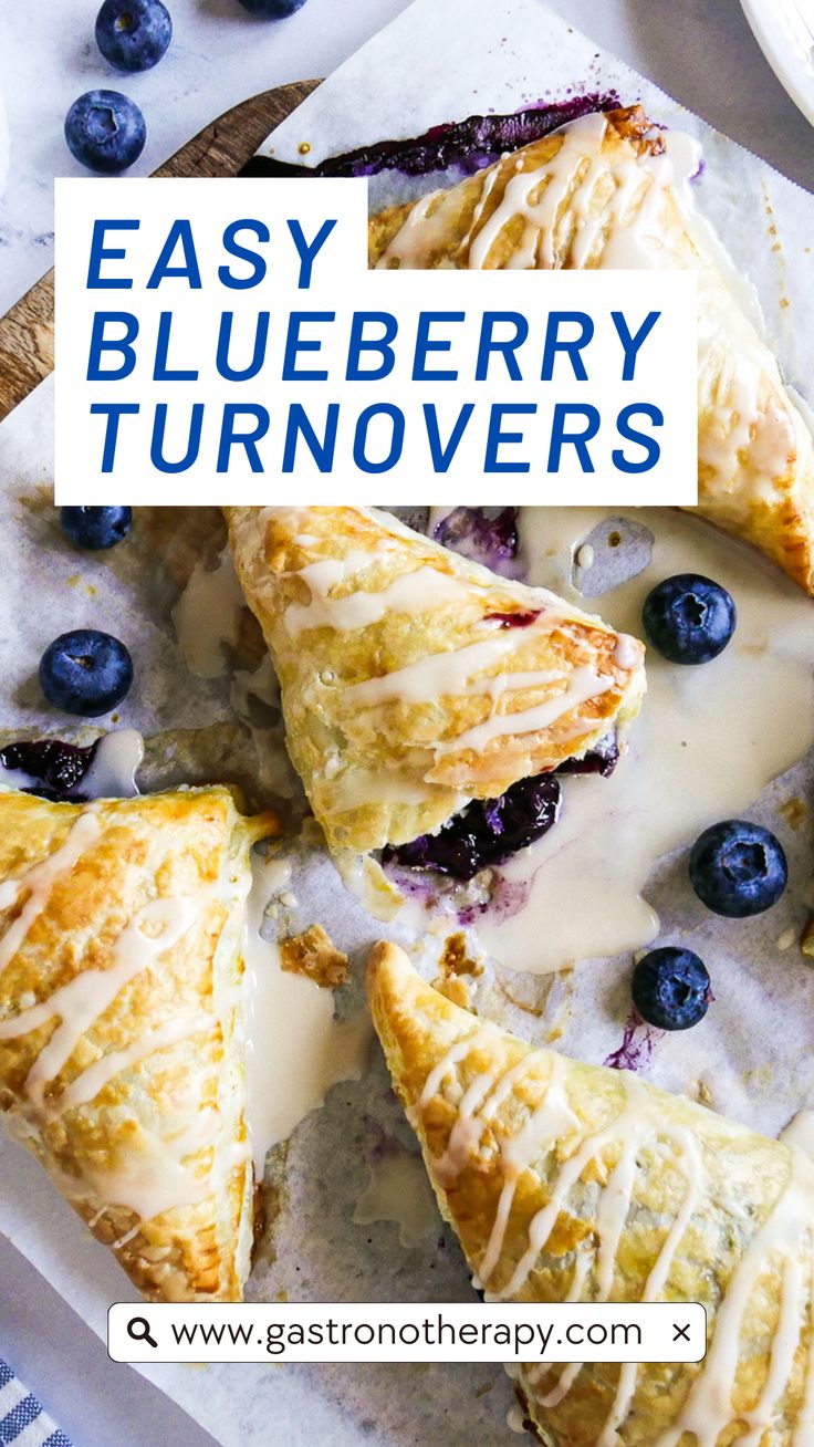 Five blueberry turnovers arranged on parchment paper with icing and fresh blueberries. Easy Blueberry Turnovers, Puff Pastry Recipes Turnovers, Blueberries Puff Pastry, Blueberry Turnovers With Pie Crust, Recipes With Frozen Blueberries Baking, Easy Recipes Using Frozen Puff Pastry, Ways To Use Frozen Blueberries, Fruit Turnovers With Pie Crust, Puff Pastry With Blueberries