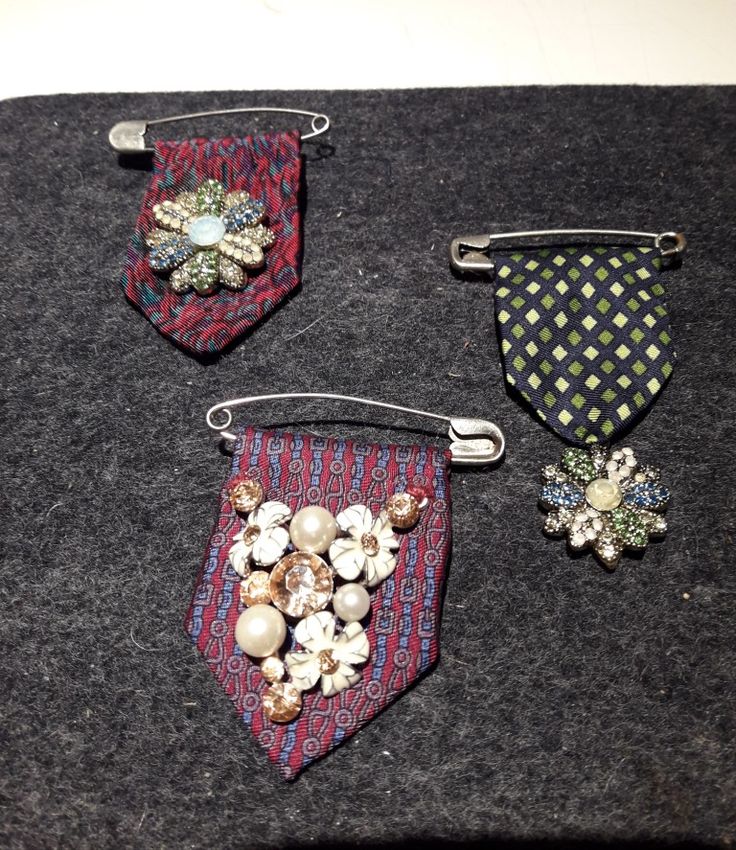 three pieces of fabric with brooches on them