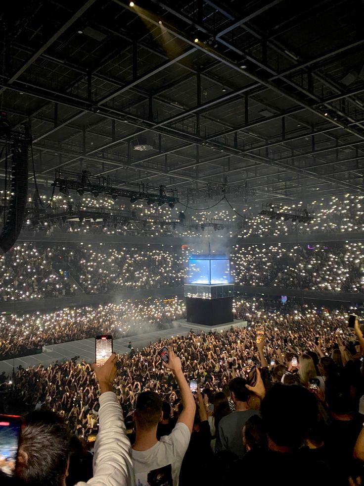 an audience at a concert taking pictures with their cell phones