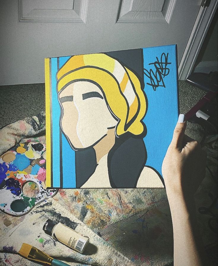 someone is painting a woman's face on a canvas