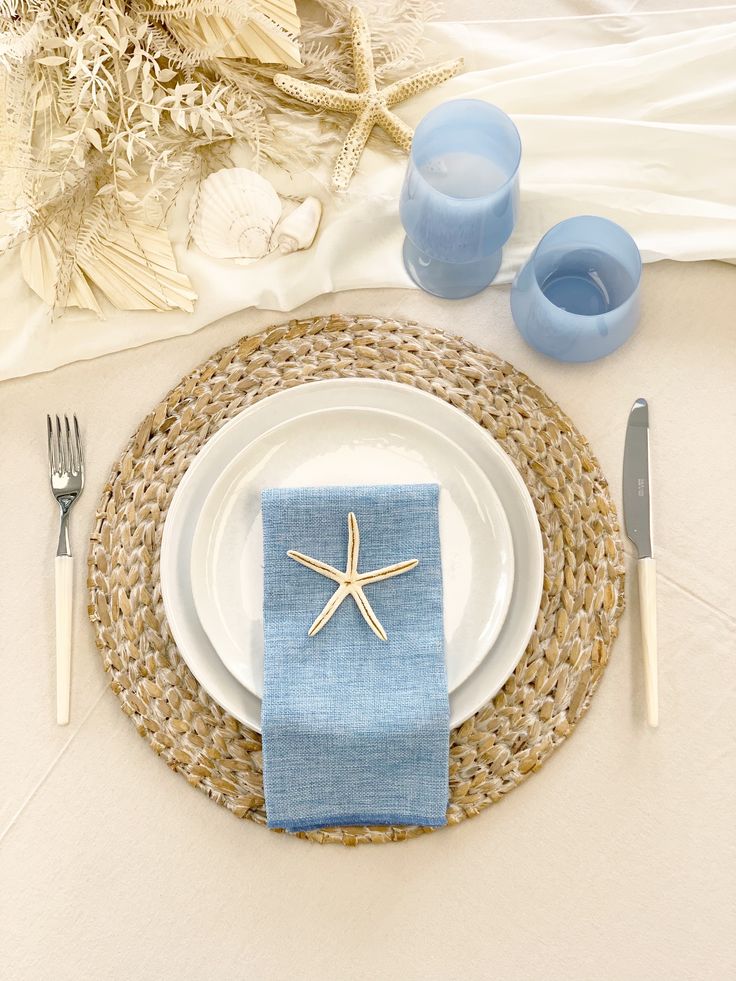 a place setting with starfish napkins and silverware