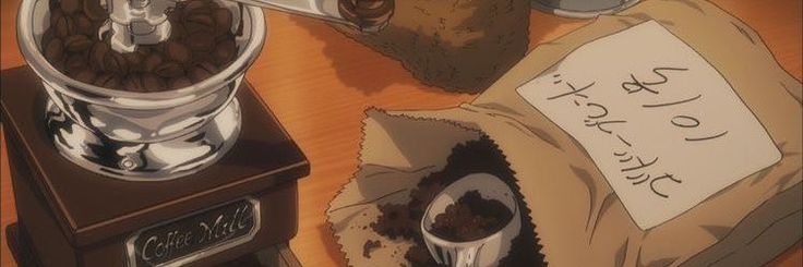 there is a coffee grinder and some beans on the table next to it,