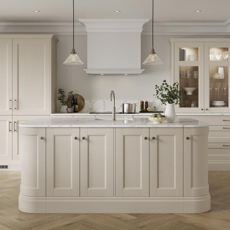 a large kitchen with white cabinets and marble counter tops, along with wooden flooring