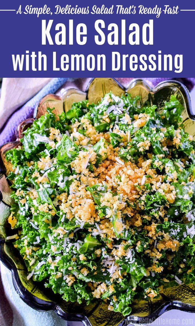 kale salad with lemon dressing in a glass bowl on top of a purple cloth