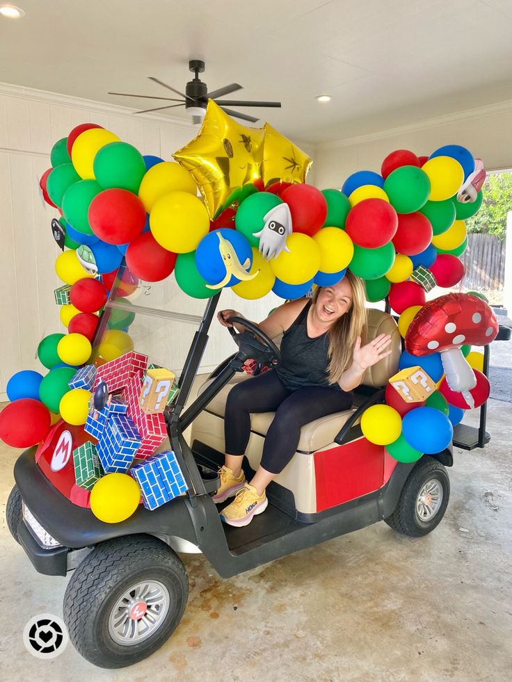 a woman in a golf cart filled with balloons