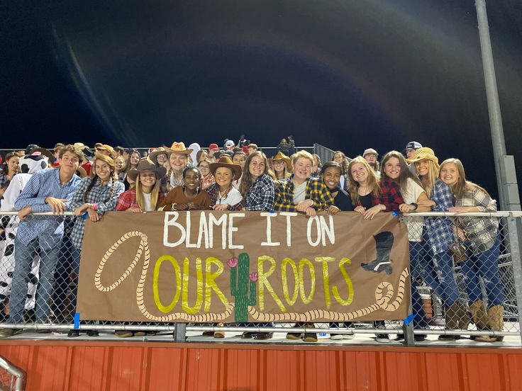 a group of people standing next to each other holding a banner that says blam it on our roots