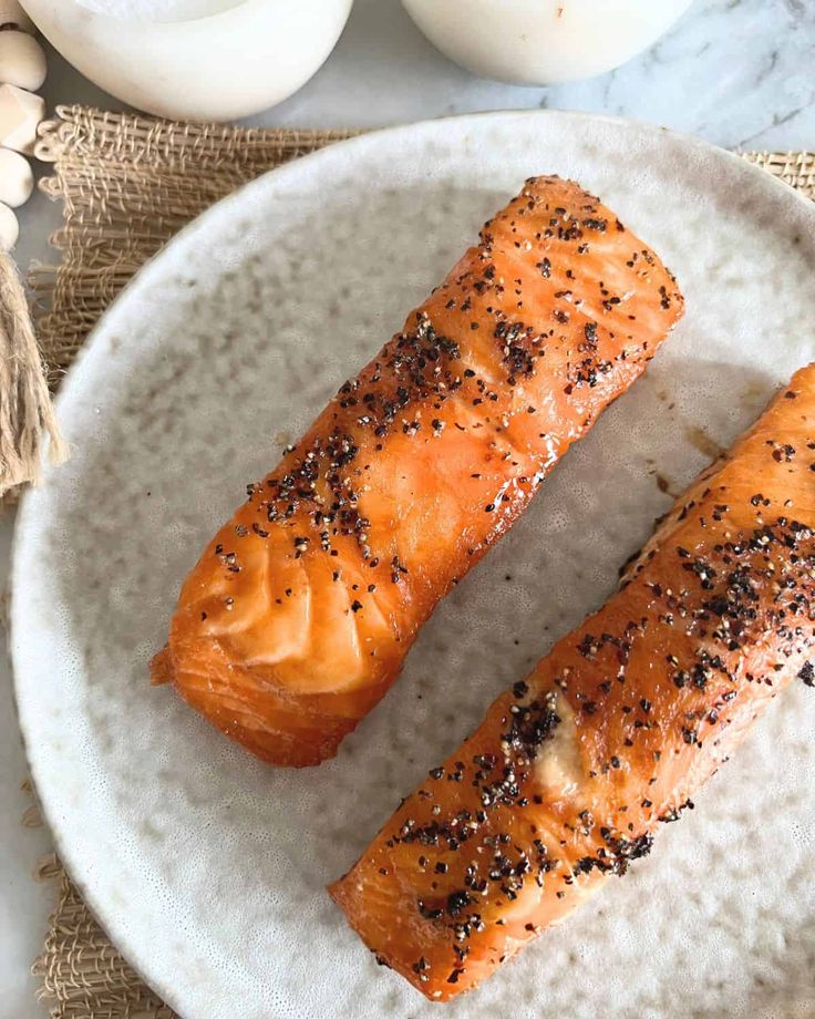 two pieces of salmon on a white plate