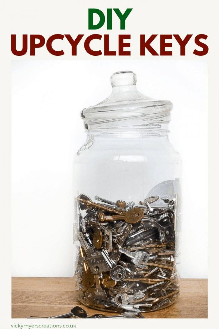 a jar filled with lots of keys sitting on top of a wooden table