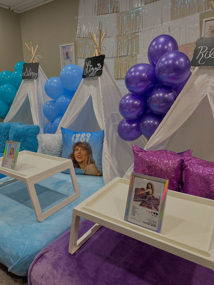 there are balloons and pictures on display in the room with purple and blue decorating