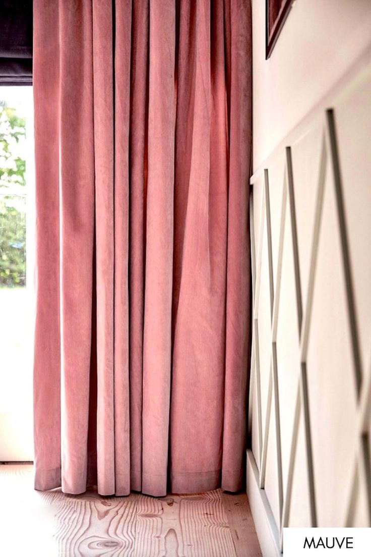 a window with pink curtains in front of it and a white wall behind the curtain