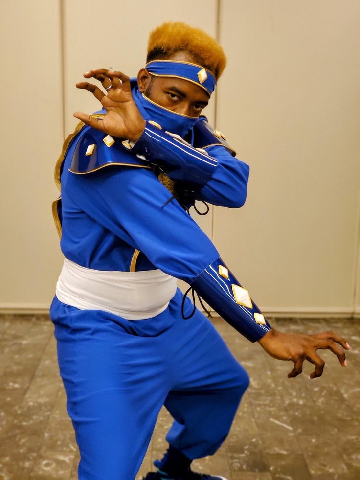 a man dressed in blue and white poses for the camera